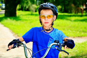 Boy wearing safety glasses and riding bicycle